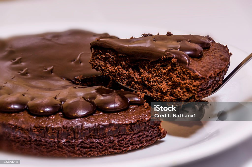 slice of chocolate fudge cake on a white plate slice of chocolate fudge cake on a white plate with a white background, colour image, shot in the studio with a nikon d7000 dslr camera Baked Stock Photo