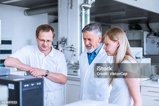 Team Of Researchers Carrying Out Experiments Stock Photo - Download Image Now - Laboratory, Adult, Analyzing