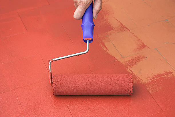 istock Hand painting a red floor with a paint roller 523600015