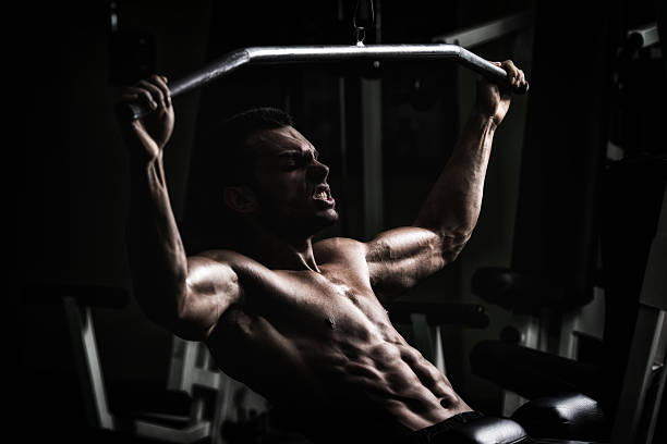 bodybuilder fazendo exercícios de peso pesado para trás - flexing muscles men human muscle human arm - fotografias e filmes do acervo