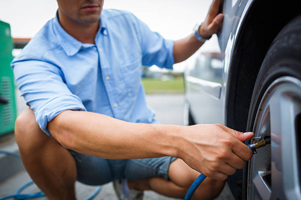 Driver checking air pressure in the wheel