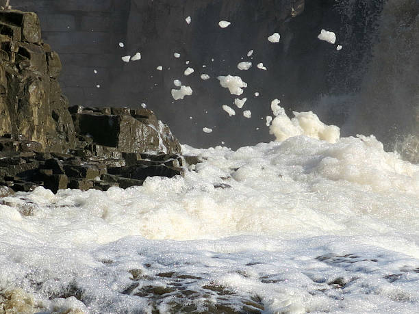 Foam from the Sioux Falls blows up from the wind of the waterfall.