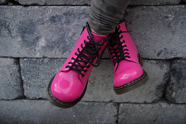 Pink punk alternative girl or woman shoes - cross legged stock photo