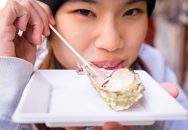 istock Japanese girl Eating Fresh Oyster 523617796
