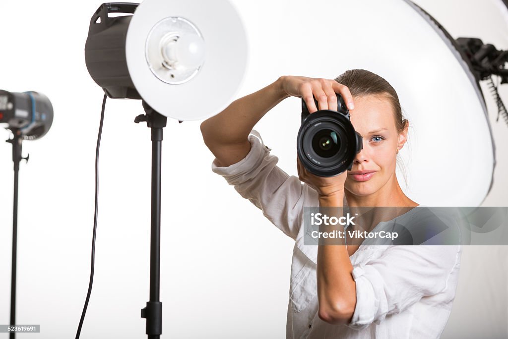 Pretty, female photographer Pretty, female photographer with digital camera - DSLR on a white background  (color toned image; shallow DOF) Adult Stock Photo