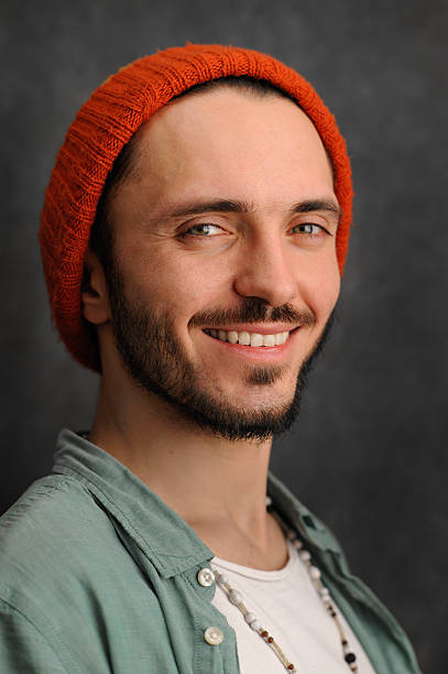istock Smiling young man with beard and moustache in red cap 523623384
