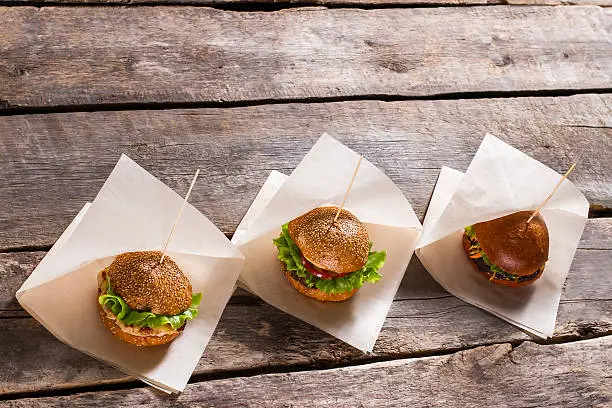 Photo of Burgers on white wrappers.