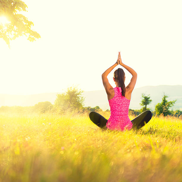 istock Young athletic woman practicing yoga on a meadow at sunset 523624518
