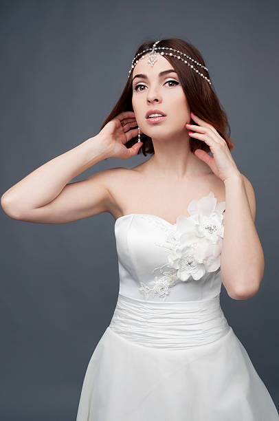 istock Brunette bride wearing tikka headpiece and white wedding dress 523626014