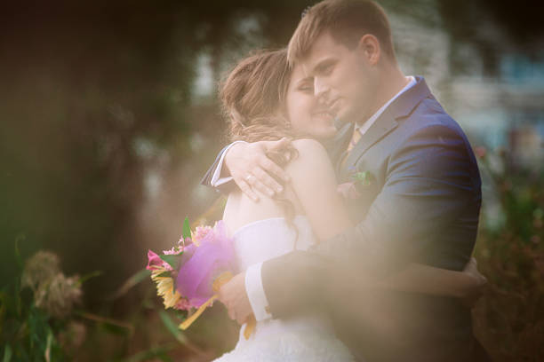 istock Young attractive bridal couple holding hands outdoors next to tree 523628192