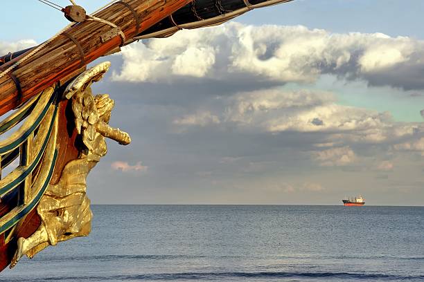 Wooden Carved Figurehead found at the Prow of Old Ship Female Wooden Carved Figurehead found at the Prow of Old Ship. Modern ship at sea horizon. figurehead stock pictures, royalty-free photos & images