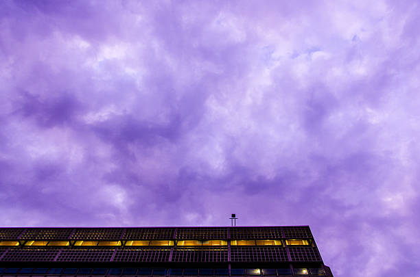 Cloudy purple sky over building Purple clouds over a building. university of massachusetts amherst stock pictures, royalty-free photos & images