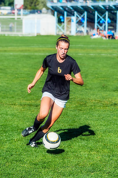 istock Young Female Soccer Player in Black Concentrates on Bouncing Ball 523634615