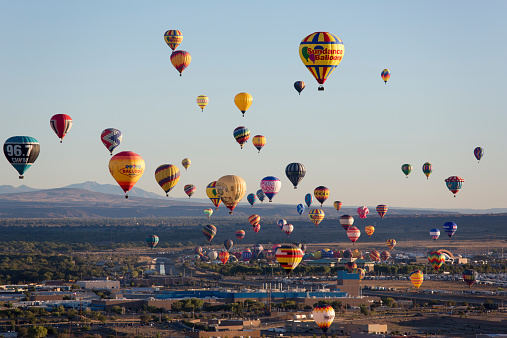 A single hot air balloon floating in the clouds during a balloon festival.