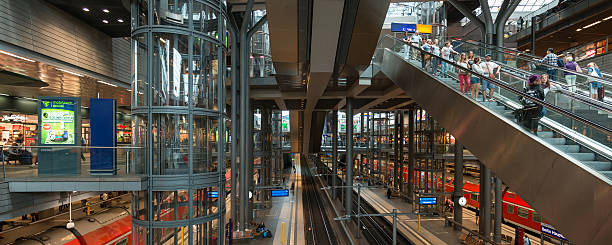 Berlin, Germany - August 12, 2014: People walking inside the Berlin Hauptbahnhof - central railway station. This railway station has many levels for trains, shops, S-Bahn and restaurants. The  modern building is made of a lot of glass and small columns.