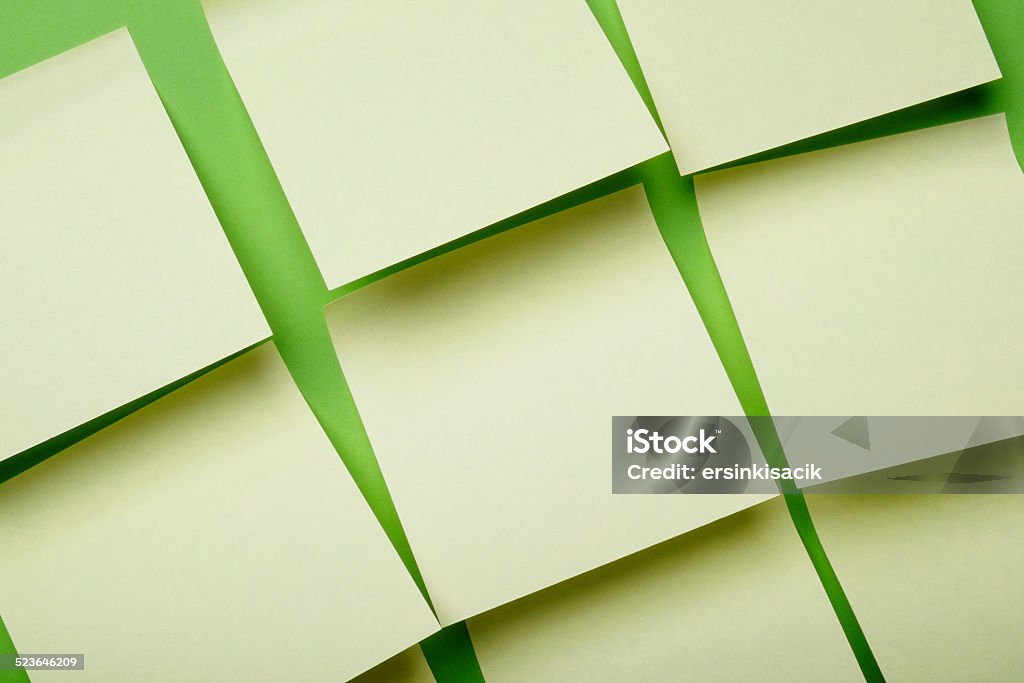 Adhesive notes on green wall yellow sticky post its  on green wall. Adhesive Note Stock Photo