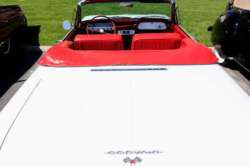 Palm Springs, California,United States- March 24,2013: Photographed from the Back of a Mint condition classic red and white 1961 Corvair Monza Convertible. Looking from back trunk  to front seat with steering wheel  console and dashboard. Convertible top down.