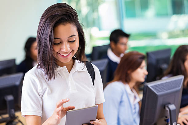 istock Cute Hispanic high school girl using digital tablet in classroom 523647179