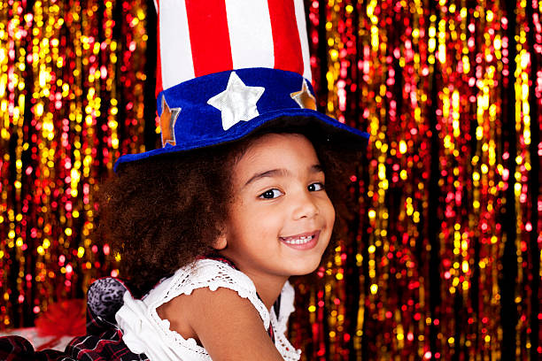 Pretty little girl with patriotic hat in front tinsel