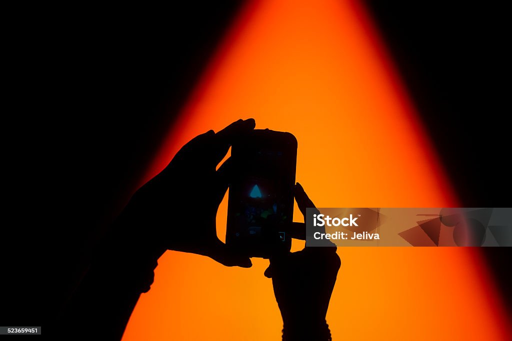 Silhouette of hands taking a photo on concert Silhouette of hand taking a photo of concert on mobile phone Arts Culture and Entertainment Stock Photo