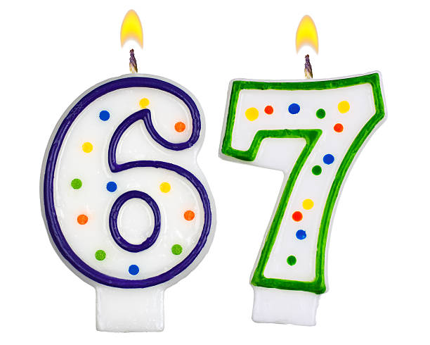 istock Birthday candles number sixty seven isolated on white background 523663983