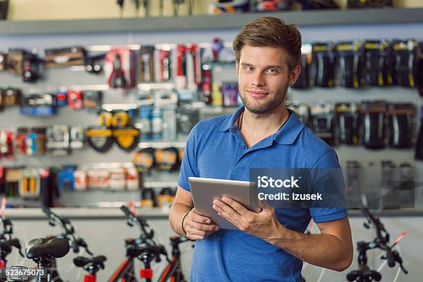 Sales Clerk With Digital Tablet In Bike Shop Stock Photo - Download Image Now - Manager, Sports Shop, Bicycle