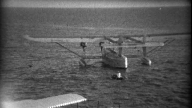 1935: Dingee boat rowing to Pan Am Sikorsky S-40 sesquiplane amphibious flying boat.