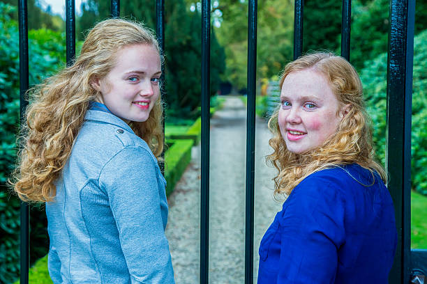 istock Two girls at gate of footpath in park 523680465