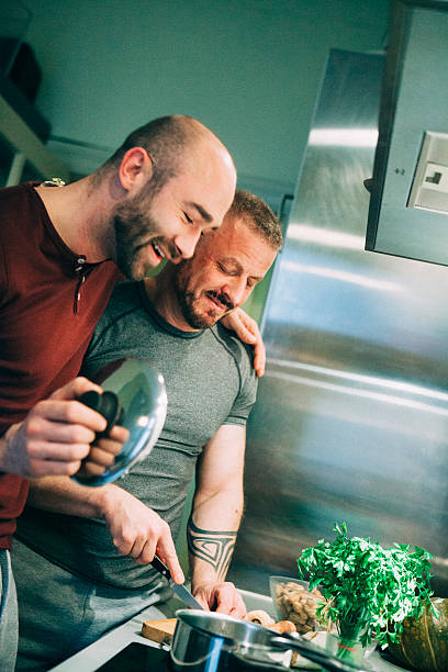 istock gay couple preparing the meal in the kitchen 523680961