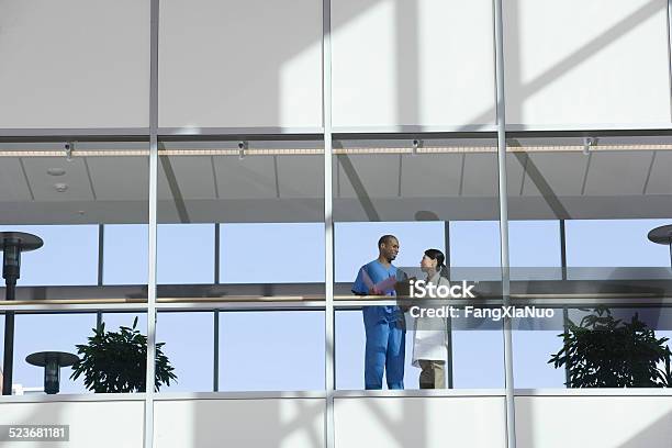 Two Doctors Talking In Corridor Stock Photo - Download Image Now - Hospital, Building Exterior, Outdoors