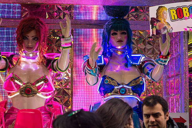 Tokyo, Japan - March 27, 2016: The window display of Robot Restaurant in Shinjuku, where bikini-clad women take to the floor on giant robots to entertain customers. People can be seen in front of the window, and mannequin sized models behind it. 