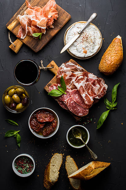 set vino spuntino. bicchiere di rosso, carne scelta, olive mediterraneo - antipasto appetizer basil bread foto e immagini stock