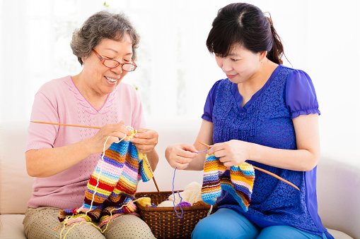 happy Senior mother and  daughter  learning knitting