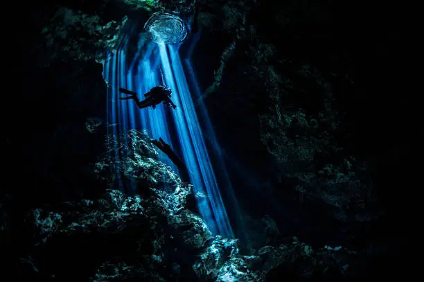 Photo of Rays of light in dark underwater cave