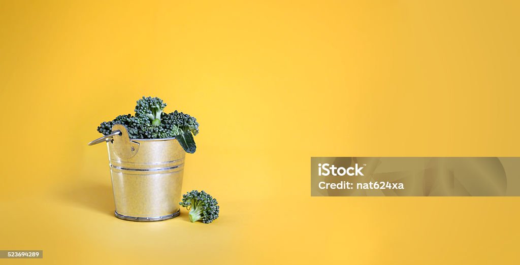 Broccoli in a bucket on yellow background Agriculture Stock Photo