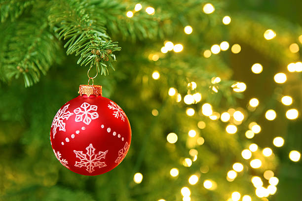 Montaje de bola de Navidad rojo en árbol de Navidad con luces borrosas - foto de stock