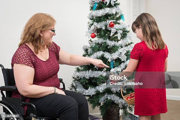 Tochter Mit Mutter Dekorieren Weihnachtsbaum Im Rollstuhl Stockfoto und mehr Bilder von Andersfähigkeiten