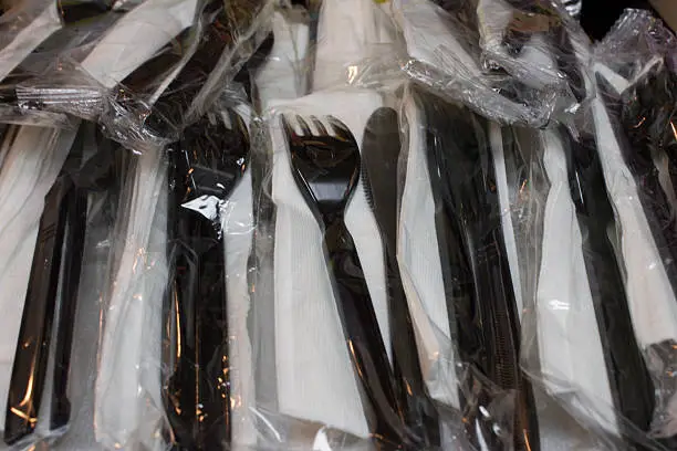 This is a photograph of Plastic disposable forks and knives with napkins