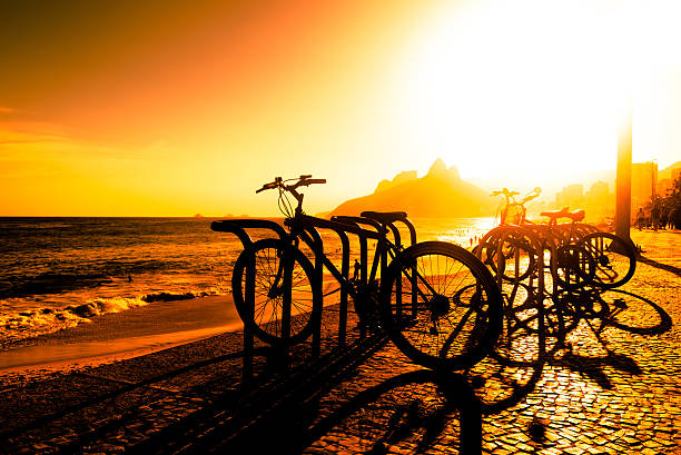 sonnenuntergang am strand - brazil bicycle rio de janeiro outdoors stock-fotos und bilder