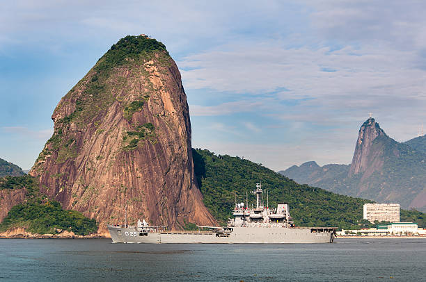 Rio de Janeiro, Brazil - February 26, 2016: G-26 Almirante Saboia, Brazilian navy battleship passing near the Sugarloaf Mountain in Guanabara Bay.