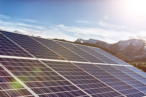 solar panels against a sunny sky with sun flares