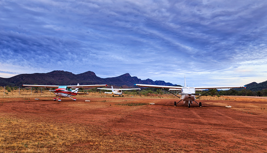 Small commercial airplanes grounded near Wilpena Pound mountains in Flinders ranges national park shoot at sunrise.