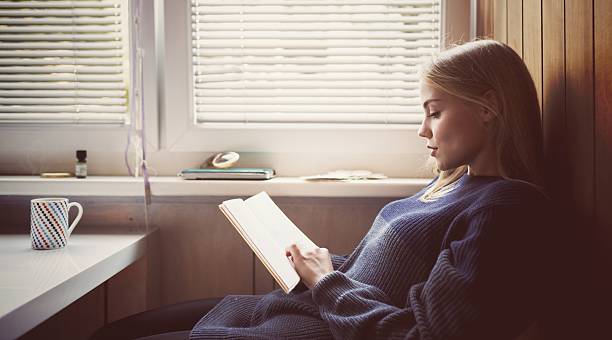 istock Young female student reading book in the kitchen 523697579