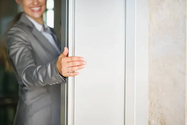 Photo of closeup on business woman hand holding elevator door