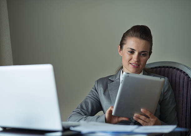 istock business woman working with tablet pc in hotel room 523698587