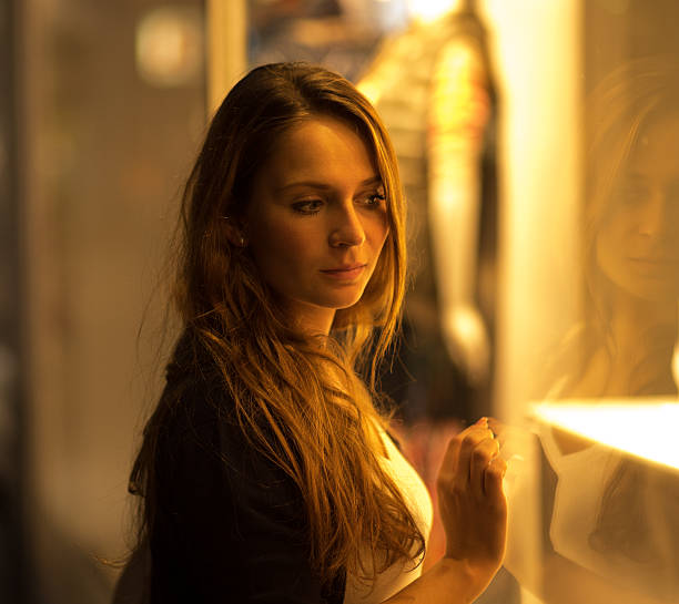 istock Woman looking into shop window at night 523698673