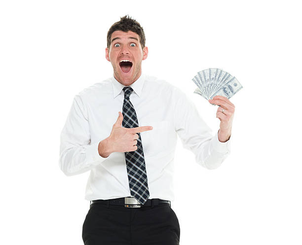 istock Cheerful businessman pointing at money 523701184