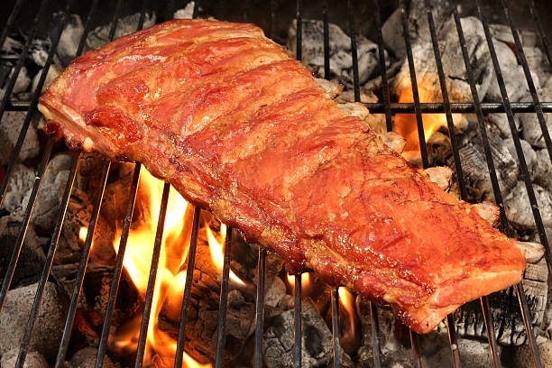 cerdo o chuletas de cerdo cerdo a la barbacoa a la parrilla con llamas - rubbing spice rib barbecue fotografías e imágenes de stock