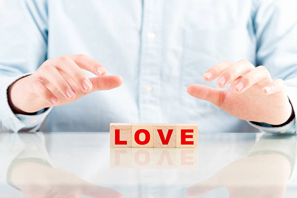 istock protective hands above wooden cube with word love 523709411