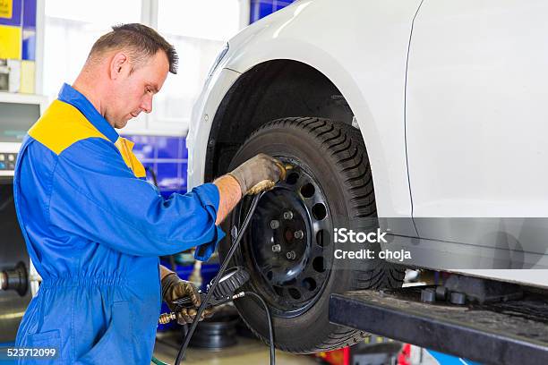 Auto Mechanic Is Changin Tireprepairing Car For Winter Stock Photo - Download Image Now